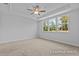 Bright bedroom featuring tray ceilings, a ceiling fan, and multiple windows that provide ample natural light at 112 Cultivator Ct, Angier, NC 27501