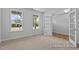Bright bedroom featuring carpeted floors, large windows, and a door leading to another room at 112 Cultivator Ct, Angier, NC 27501