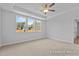 Bedroom with tray ceilings, a ceiling fan, and a view of the neighborhood outside the window at 112 Cultivator Ct, Angier, NC 27501