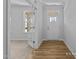 Inviting foyer featuring wood flooring, a white front door, and an adjacent room with carpeted floors at 112 Cultivator Ct, Angier, NC 27501