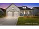 Inviting two-story home with a well-manicured lawn, complemented by an attached two-car garage at 112 Cultivator Ct, Angier, NC 27501