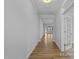 Hallway with wood floors leading to a bright, open area with views of the outdoors at 112 Cultivator Ct, Angier, NC 27501