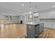 Open-concept kitchen featuring a kitchen island, sleek countertops, and modern appliances at 112 Cultivator Ct, Angier, NC 27501