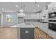 Modern kitchen with white cabinets, a kitchen island with sink, and stainless steel appliances at 112 Cultivator Ct, Angier, NC 27501