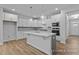 Elegant kitchen boasting white cabinets, stylish pendant lights, and stainless steel appliances at 112 Cultivator Ct, Angier, NC 27501