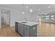 Open-concept kitchen with a gray island, stainless steel appliances, and views of the living area at 112 Cultivator Ct, Angier, NC 27501
