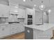 Stylish kitchen with white cabinets, a kitchen island, and modern stainless steel appliances at 112 Cultivator Ct, Angier, NC 27501