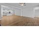 Open-concept living room showcasing wood floors that flow into a modern, white kitchen with a center island at 112 Cultivator Ct, Angier, NC 27501