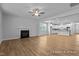 Open-concept living room featuring a fireplace and wood floors, flowing into an adjacent kitchen at 112 Cultivator Ct, Angier, NC 27501