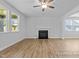 Spacious living room with wood floors and a fireplace, illuminated by natural light from large windows at 112 Cultivator Ct, Angier, NC 27501