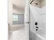 Bathroom with tile floors, white walls, and white tub-shower with black fixtures at 112 River Dell Townes Ave, Clayton, NC 27527