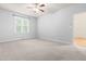 Spacious bedroom with a ceiling fan and neutral carpeting with an open doorway to another room at 112 River Dell Townes Ave, Clayton, NC 27527
