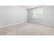 Cozy carpeted bedroom with a bright window providing natural light and a pleasant view at 112 River Dell Townes Ave, Clayton, NC 27527