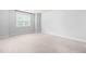 Bright bedroom with neutral carpet, light gray walls, and a window with a view at 112 River Dell Townes Ave, Clayton, NC 27527
