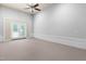 Large bonus room featuring carpeting, ceiling fan and backyard access through french doors at 112 River Dell Townes Ave, Clayton, NC 27527