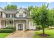 Charming home featuring stone accents, a metal roof, and lush landscaping at 112 River Dell Townes Ave, Clayton, NC 27527