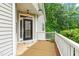 Inviting porch with a black front door, white railings, and a cozy welcome mat at 112 River Dell Townes Ave, Clayton, NC 27527