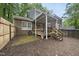 Spacious backyard featuring a wooden deck with stairs, lush landscaping, and brick accents at 1200 Collington Dr, Cary, NC 27511