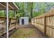 Backyard view with a covered deck, a storage shed, brick and moss ground cover, and a wooden fence at 1200 Collington Dr, Cary, NC 27511