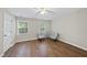 This bedroom features sleek wood floors, two windows, ceiling fan, and painted in modern neutral tones at 1200 Collington Dr, Cary, NC 27511
