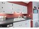 Well-lit kitchen featuring a white double sink, black countertops, and white cabinets against a two-tone wall at 1200 Collington Dr, Cary, NC 27511