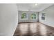A sunny bedroom with wood-look floors and two windows with tree-filled backyard views at 1216 Briarwood Dr, Mebane, NC 27302