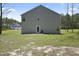 Back of a gray two-story home with a sliding glass door and expansive yard, offering outdoor living space at 124 Teagarden Ct, Sanford, NC 27332