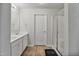 Bathroom with double sink vanity, wood-look flooring, a sliding glass shower door, and a white interior door at 124 Teagarden Ct, Sanford, NC 27332