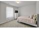 Bright bedroom featuring neutral carpet, a window, and a bed with soft pink linens at 124 Teagarden Ct, Sanford, NC 27332