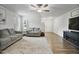 Bright living room featuring hardwood floors, a ceiling fan, and two comfortable gray sofas at 124 Teagarden Ct, Sanford, NC 27332