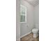 Toilet located in a bright room with wood-look flooring and natural light from window at 124 Teagarden Ct, Sanford, NC 27332