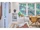 Bright dining area featuring a round wooden table, modern chairs, built-in shelving, and a view of the lush greenery at 126 Weaver Rd, Chapel Hill, NC 27514