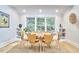 Bright dining area with modern wooden table and chairs, built-in shelving, and a large window with natural light at 126 Weaver Rd, Chapel Hill, NC 27514