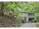 View of home exterior featuring covered parking, a screened-in porch, wood steps, and hillside landscaping at 126 Weaver Rd, Chapel Hill, NC 27514