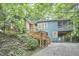 View of home exterior featuring covered parking, a screened-in porch, wood steps, and hillside landscaping at 126 Weaver Rd, Chapel Hill, NC 27514