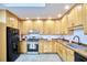 Bright kitchen featuring natural wood cabinets, stainless steel appliances, and tile flooring under a skylight at 126 Weaver Rd, Chapel Hill, NC 27514