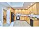 Bright kitchen featuring natural wood cabinets, stainless steel appliances, and tile flooring under a skylight at 126 Weaver Rd, Chapel Hill, NC 27514