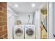 Laundry room with washer, dryer, shelving, and access to an adjacent space at 126 Weaver Rd, Chapel Hill, NC 27514