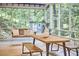 Screened-in porch featuring a swing, dining table, and wooded views perfect for relaxing and entertaining at 126 Weaver Rd, Chapel Hill, NC 27514