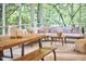 Charming screened porch with comfortable seating, a wooden dining table, and picturesque views of the surrounding trees at 126 Weaver Rd, Chapel Hill, NC 27514