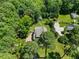 Aerial view of a home nestled among mature trees with extensive yard space and a long driveway at 12636 Old Creedmoor Rd, Raleigh, NC 27613