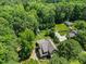 Aerial view of a home with a large lot, mature trees, long driveway, and a detached garage at 12636 Old Creedmoor Rd, Raleigh, NC 27613