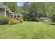 Spacious backyard with lush greenery, mature trees, and a detached building at 12636 Old Creedmoor Rd, Raleigh, NC 27613