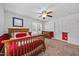 Bright bedroom featuring a wood bed, ceiling fan, and natural light from two windows at 12636 Old Creedmoor Rd, Raleigh, NC 27613