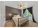 Bedroom with patterned wallpaper, a queen size bed, and ample light from the window at 12636 Old Creedmoor Rd, Raleigh, NC 27613