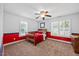 Cozy bedroom with a wood bed, ceiling fan, and natural light from two windows at 12636 Old Creedmoor Rd, Raleigh, NC 27613