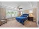 Well-lit bedroom features tray ceiling, chandelier, and large windows overlooking the outdoor landscape at 12636 Old Creedmoor Rd, Raleigh, NC 27613