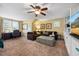 Cozy living room features plush sofa, ceiling fan, carpeting, and lots of natural light from the large windows at 12636 Old Creedmoor Rd, Raleigh, NC 27613
