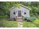 Charming outbuilding with neutral siding, a stone pathway, and manicured landscaping at 12636 Old Creedmoor Rd, Raleigh, NC 27613