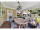 Cozy covered porch with an outdoor dining area and an eye-catching light fixture at 12636 Old Creedmoor Rd, Raleigh, NC 27613
